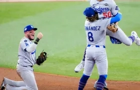 Mookie Betts, Kiké Hernández y Miguel Rojas celebran tras sacar el último out del juego. 