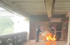 Personal de Uniatlántico mientras controla el incendio con un extintor.