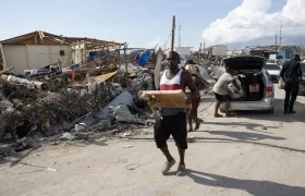 Personas afectadas por el paso del huracán Melissa recolectan objetos en Black River (Jamaica).