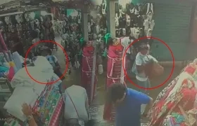 Momento en que mujer roba las dos telas.