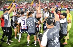 El técnico del Junior, Alfredo Arias, celebra el título con sus jugadores.