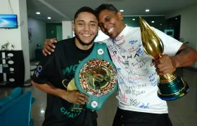 Carlos Utria con el cinturón de campeón y su papá y entrenador Lenin 