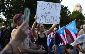 Un hombre sostiene un cartel durante una manifestación en apoyo a Venezuela en Puerto Rico. 