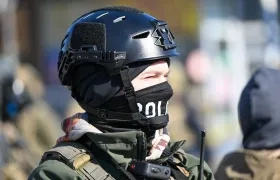 Un oficial federal hace guardia durante los enfrentamientos después de que ICE disparó fatalmente a un hombre varias veces mientras intentaban detenerlo en Minnesota.