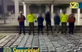 Las autoridades junto a parte de lo incautado y los tres capturados.