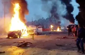 Los vehículos incendiados tras ser colisionados por la tractomula. 