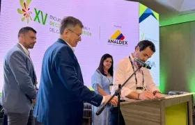 Hebert Mantilla, director de Comfamiliar Atlántico, firmando el convenio. A su lado, Javier Díaz, de Analdex.