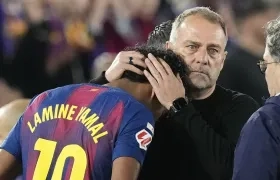 Lamine Yamal, autor del gol del Barcelona, es consolado por el técnico Hansi Flick tras salir de la cancha por lesión.