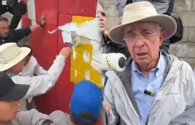 El expresidente Álvaro Uribe pintando sobre el mural.