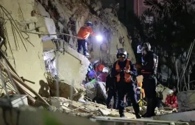 Integrantes de cuerpos de emergencia buscan víctimas.