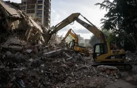 Integrantes de equipos de rescate trabajan en un edificio afectado.