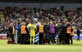 Jugadores de Dinamarca y Ucrania alrededor de Christian Eriksen después de que se desplomara.