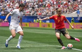 Kevin De Bruyne, de Bélgica, disputa el balón con Saeid Ezatolahi, de Irán.
