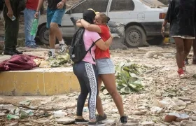 Personas lloran frente a escombros de edificios afectados por los terremotos 