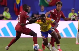 Jhon Arias intenta avanzar entre la marca de Nuno Mendes y Joao Félix.