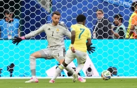 Vinicius elude al portero escocés Angus Gunn antes de marcar el primer gol de Brasil.