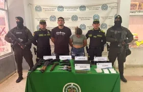 La pareja capturada junto con el arsenal de guerra incautado. 