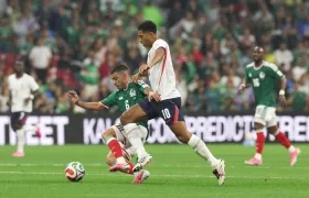  Erik Lira (i) de México disputa un balón con Jude Bellingham de Inglaterra