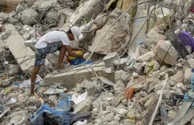 Una persona busca entre los escombros de edificios destruidos por terremotos.