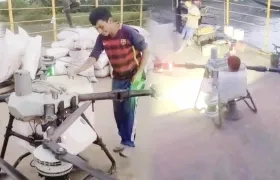 Joven sobre el dron aspersor.