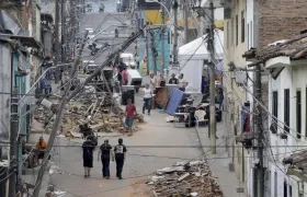 Personas caminan frente a edificaciones afectadas por el terremoto en Pereira.