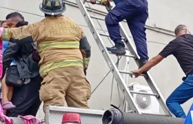 Bomberos con escaleras rescatando pacientes en el tercer piso