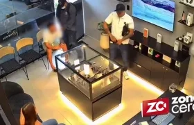 Los dos delincuentes cuando robaban el local de celulares. 