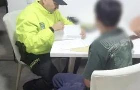 La Policía leyendo la orden de captura contra el señalado de las amenazas. 