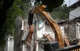 Retroexcavadora demoliendo un edificio.
