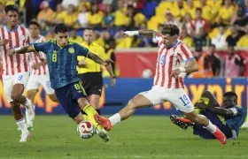 Gustavo Puerta disputa la pelota con el paraguayo Julio Enciso.
