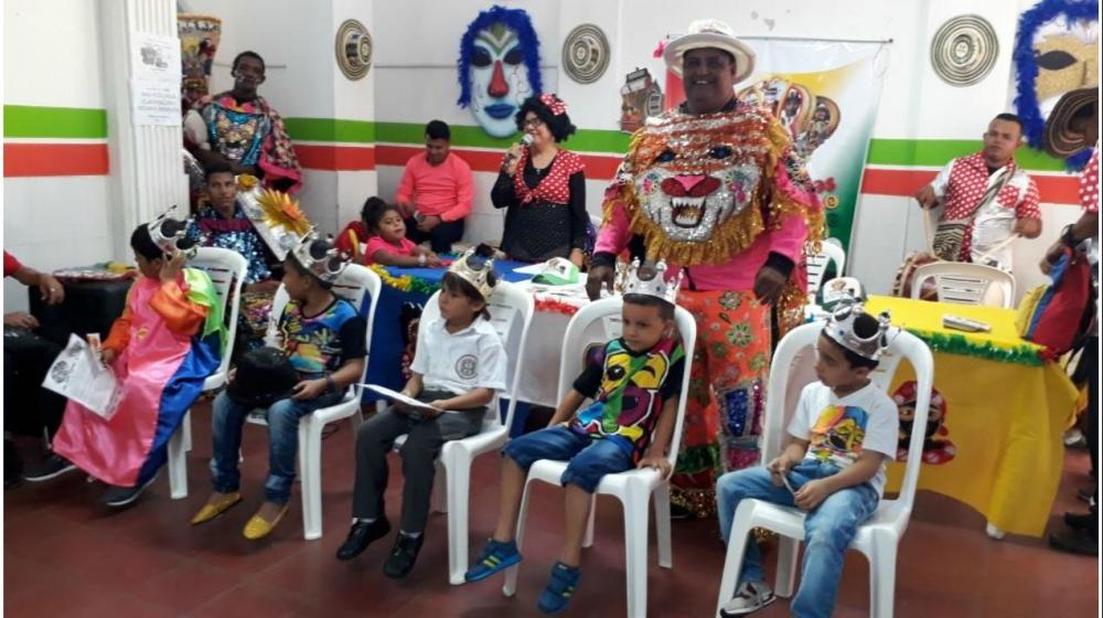 Rey Momo entrega el cetro de las fiestas a niños participantes en la iniciativa cultural.