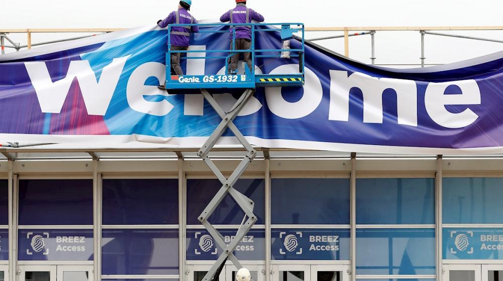 Obreros trabajan en el aviso de bienvenida al Mobile World Congress en Barcelona.