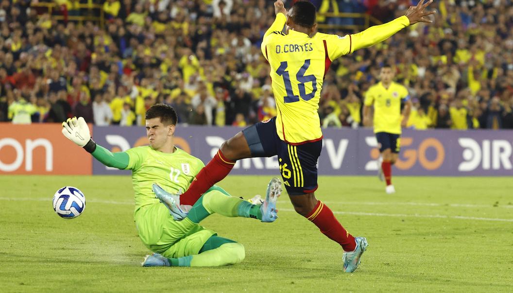 Óscar Cortés rematando frente al arquero uruguayo Lucas Rodríguez.