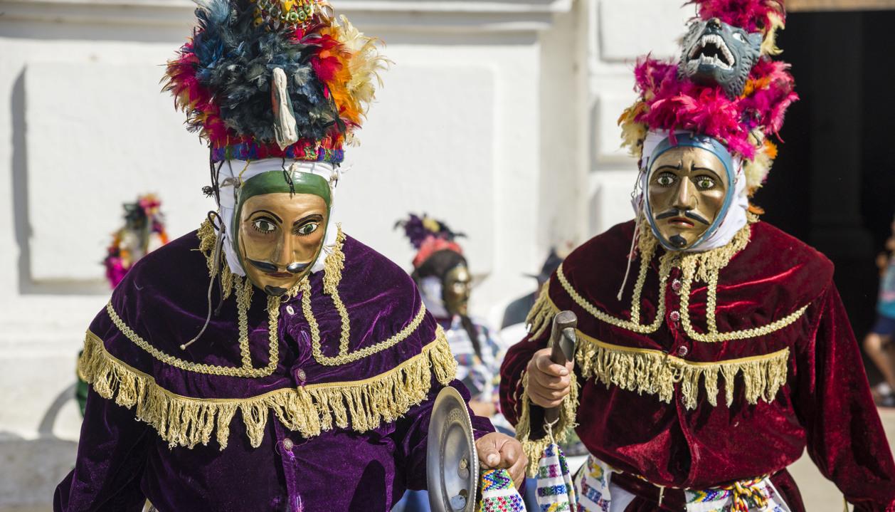 Indígenas Guatemaltecos con máscaras en un evento tradicional.