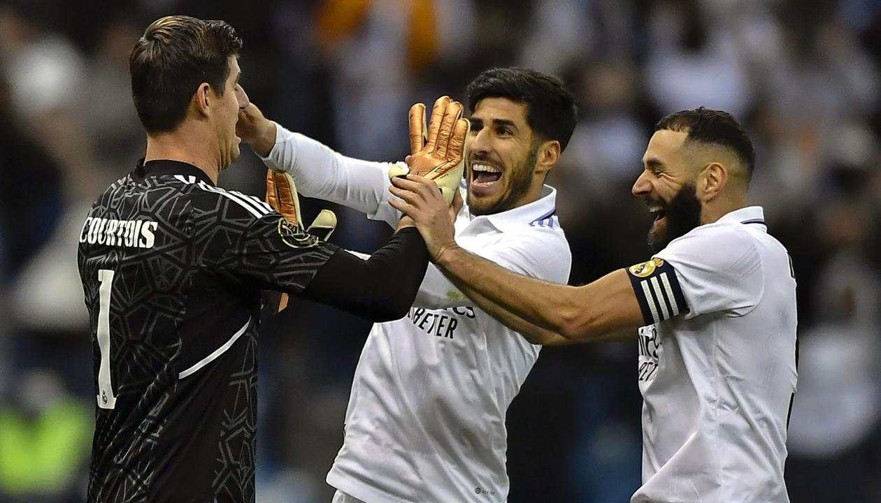 Thibaut Courtois es felicitado por Karim Benzema y Marco Asensio.