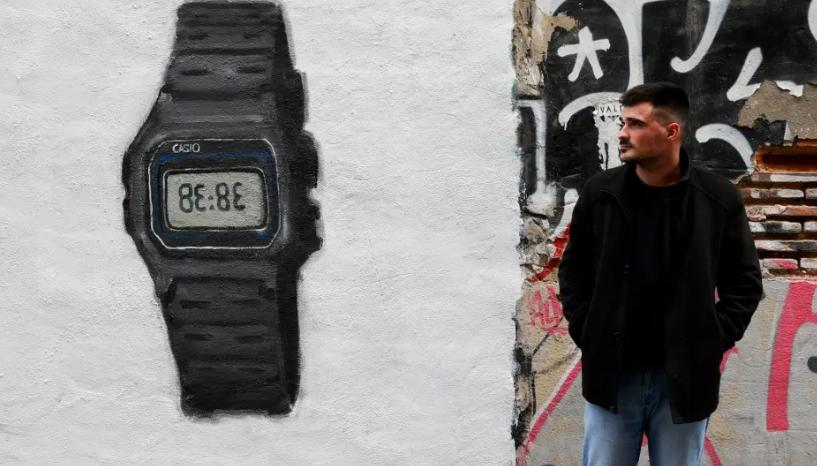 J. Warx posa ante su grafiti inspirado en el más reciente éxito de la cantante colombiana Shakira.