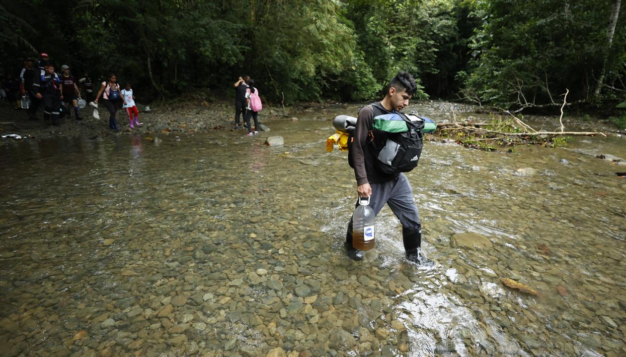 Migrantes cruzan un río en el Tapón del Daríen.