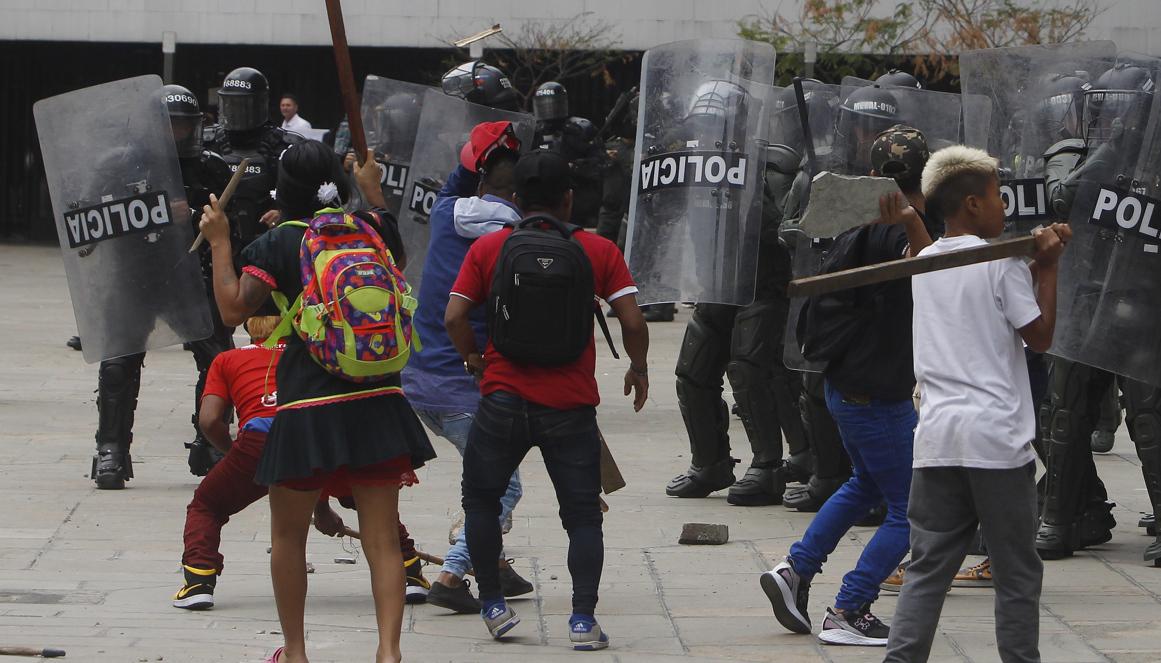 Indígenas se enfrentan durante una protesta con el Esmad de la Policía en Medellín.