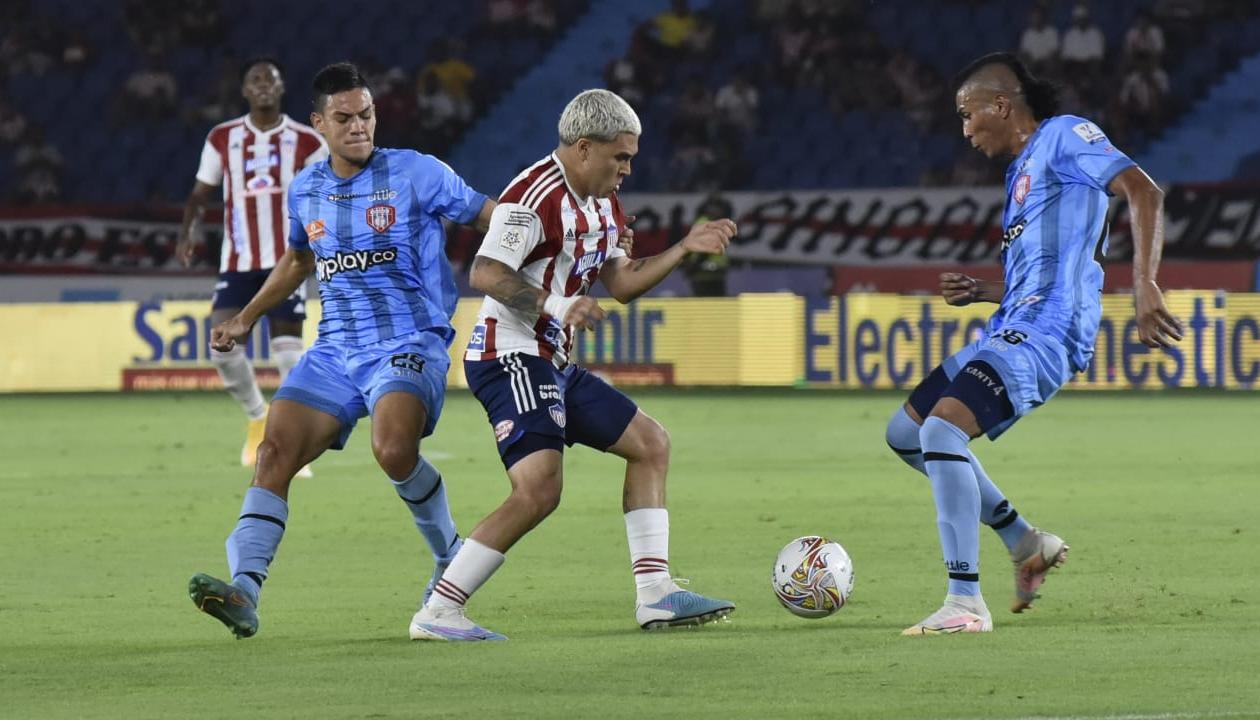 Juan Fernando Quintero intentando eludir a dos visitantes.