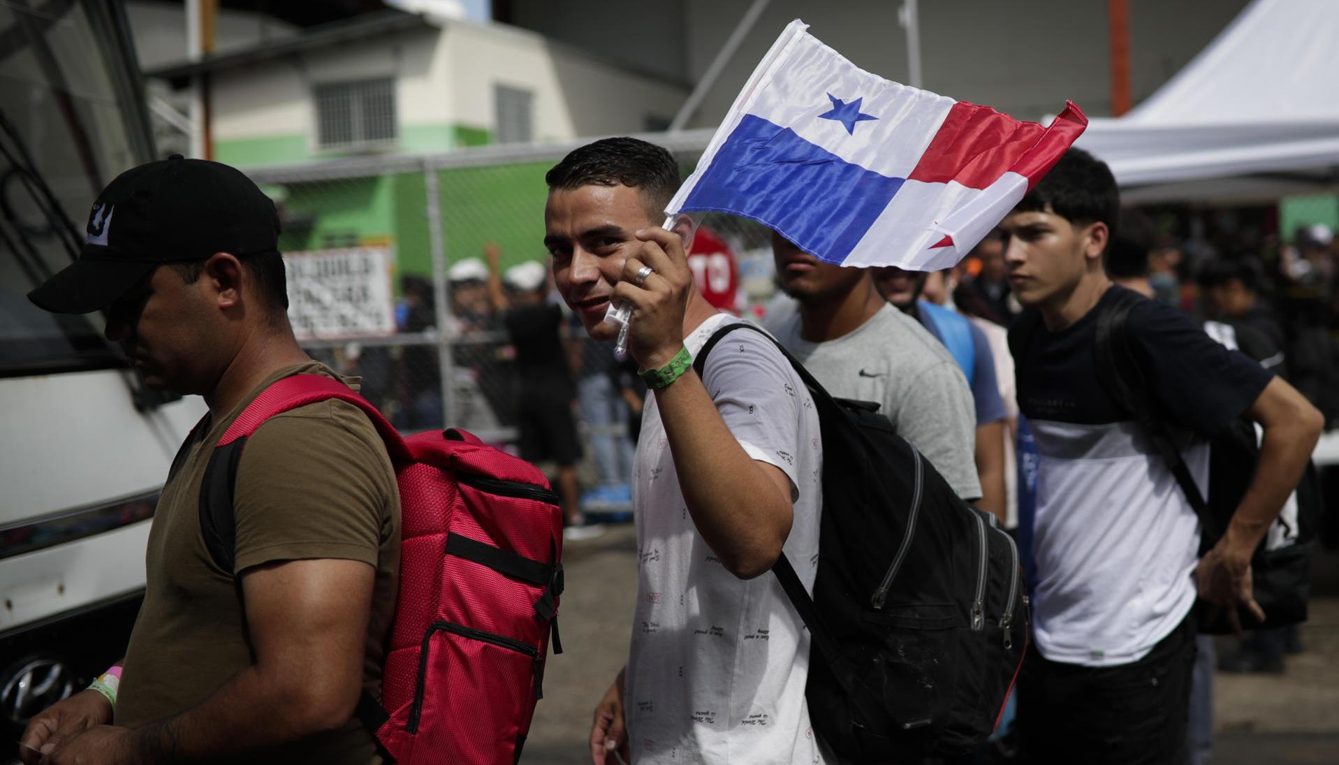 Migrantes de origen venezolano hacen fila para subir a un autobús hacia el aeropuerto internacional de Tocumen en Ciudad de Panamá.