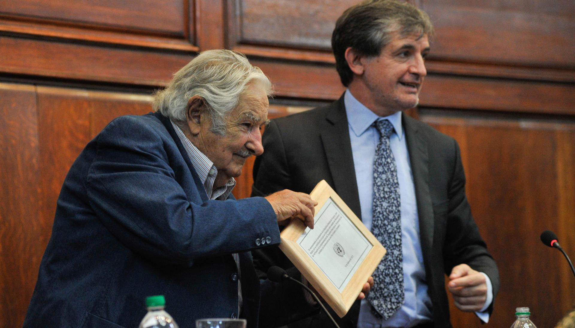 El expresidente de Uruguay José Mujica recibe un reconocimiento de manos del jefe de reincorporación de la Misión de Verificación de las Naciones Unidas en Colombia, Alessandro Preti.