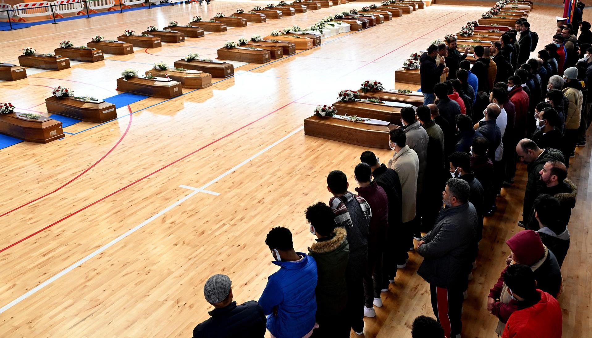 Varios ataúdes con los restos mortales de las 70 personas, entre ellas 20 menores, que murieron en las costas de Calabria, Italia, reposan en el palacio de deportes de Crotone.