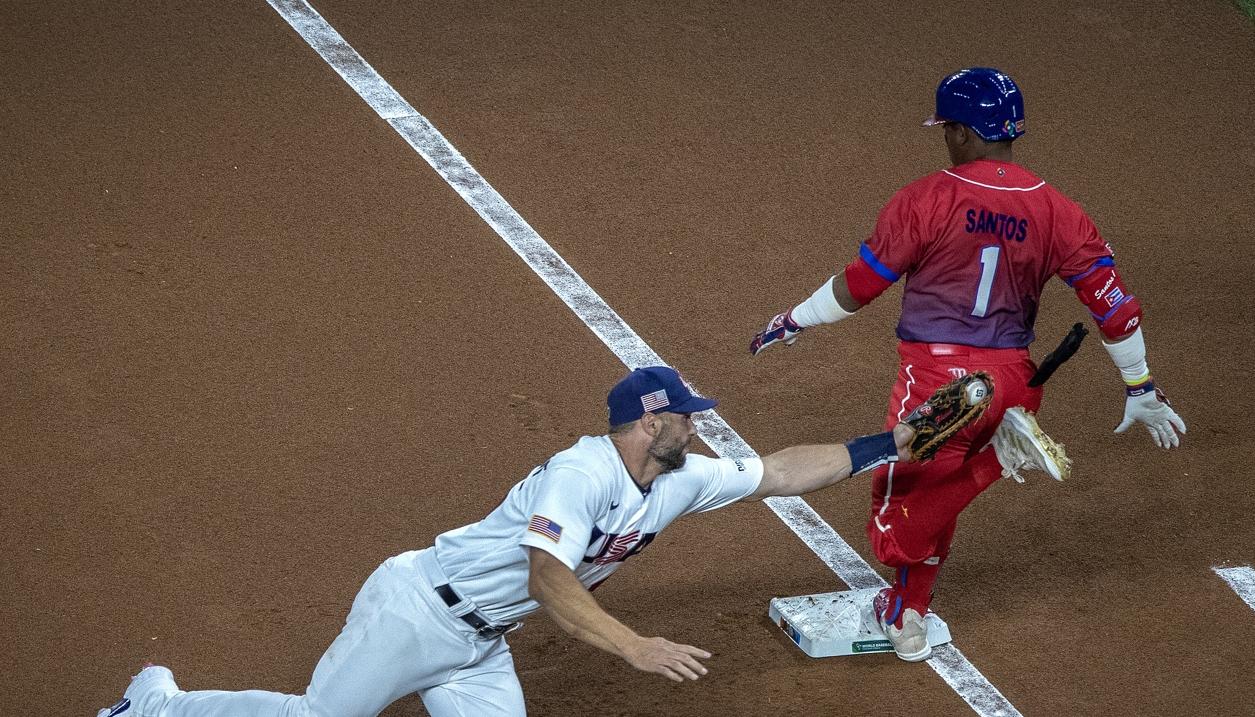 Paul Goldschmidt, de Estados Unidos, intenta poner out en primera base a Roel Santos, de Cuba. 