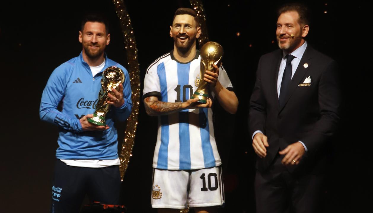 Lionel Messi, al lado de su estatua y de Alejandro Domínguez, presidente de la Conmebol.
