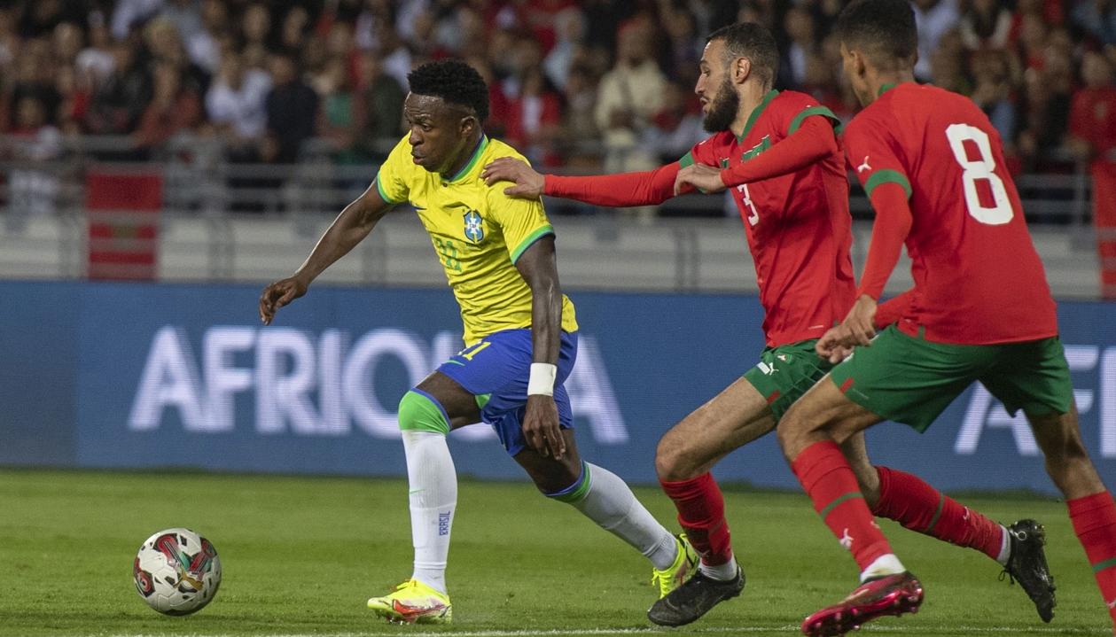 Vinicius Junior avanza ante la presión de dos jugadores marroquíes.