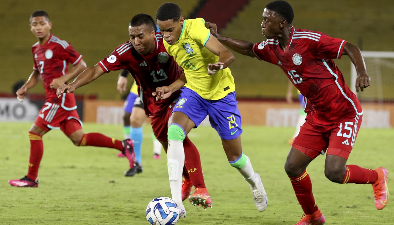 El brasileño Matheus avanza ante la marca de dos jugadores colombianos.
