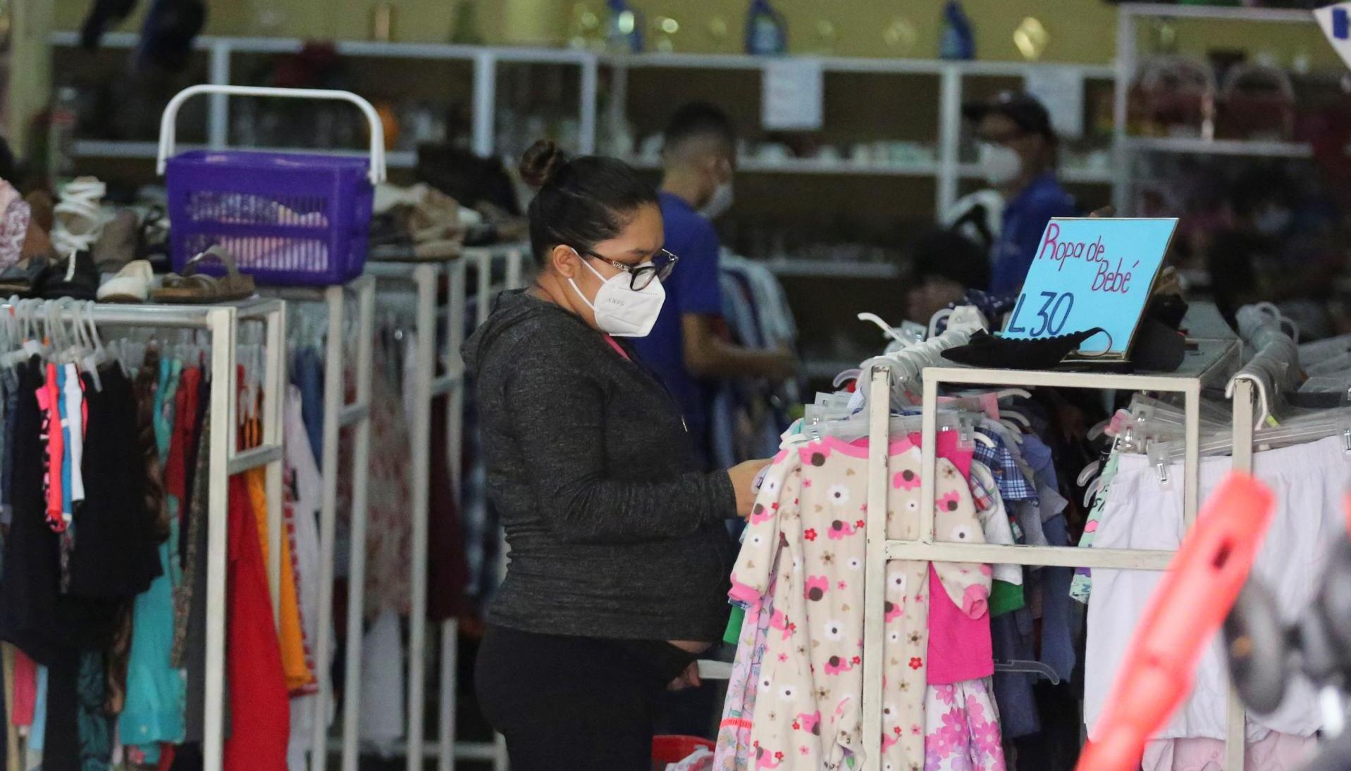 Una mujer realiza compras en una tienda de ropa usada en Tegucigalpa