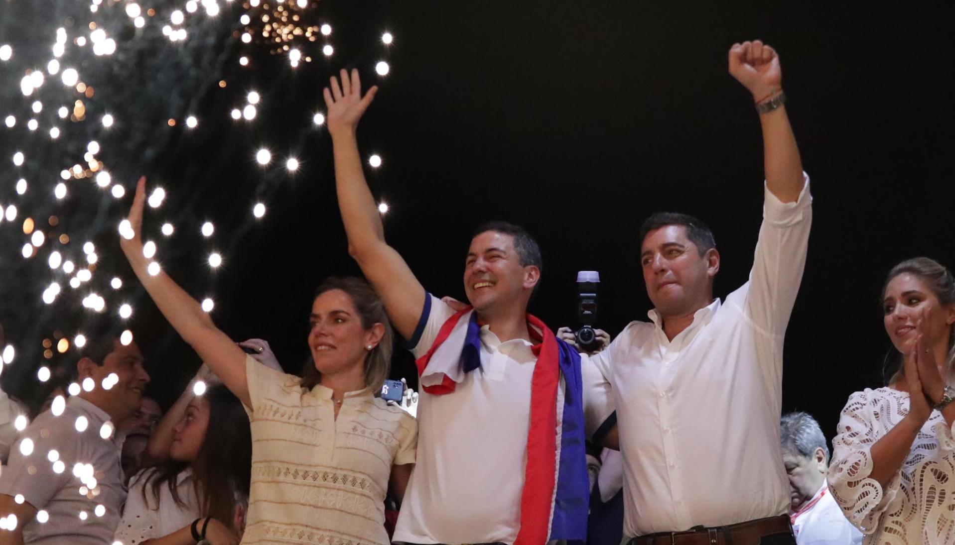 El presidente electo de Paraguay, Santiago Peña, celebra junto a su esposa Leticia Ocampos y el vicepresidente electo (der.), Pedro Alliana, tras su victoria este domingo.