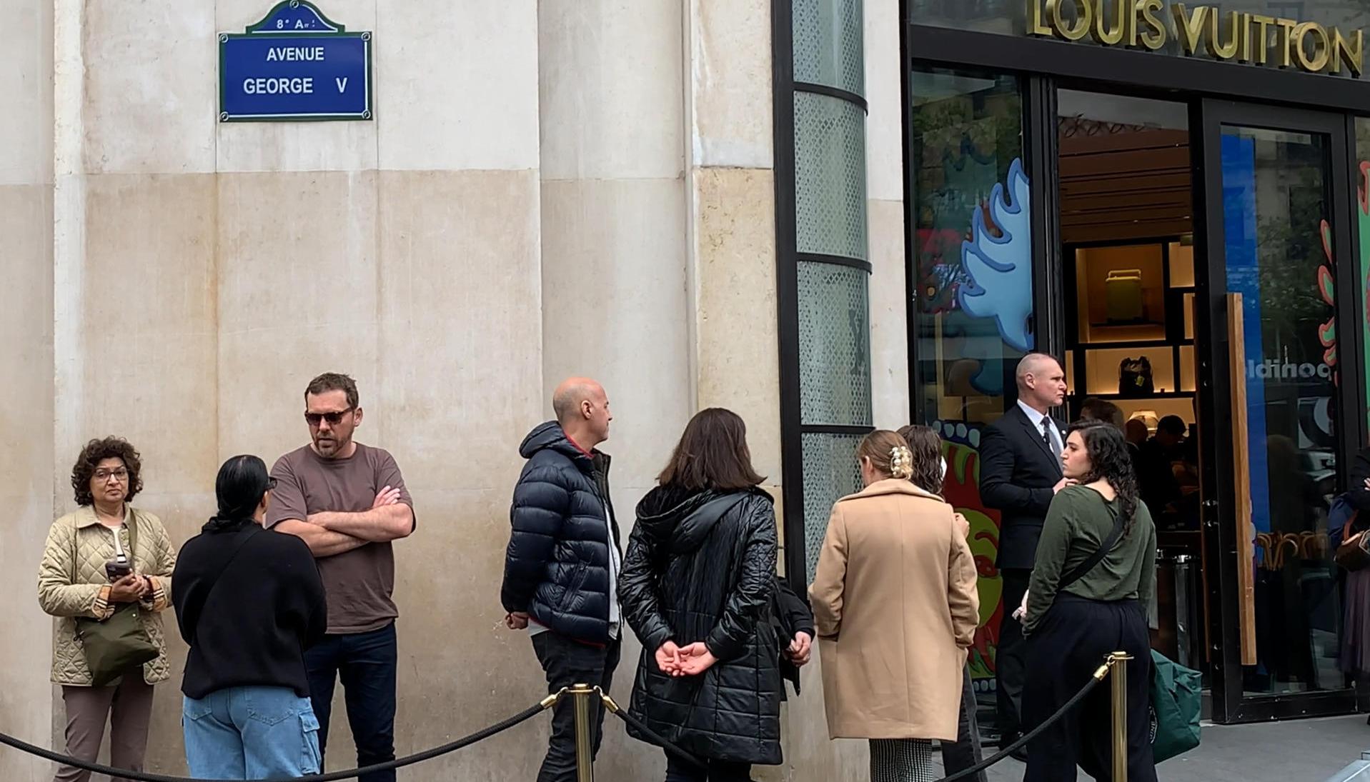 Varias personas esperan en la puerta de una tienda de lujo este sábado en París.