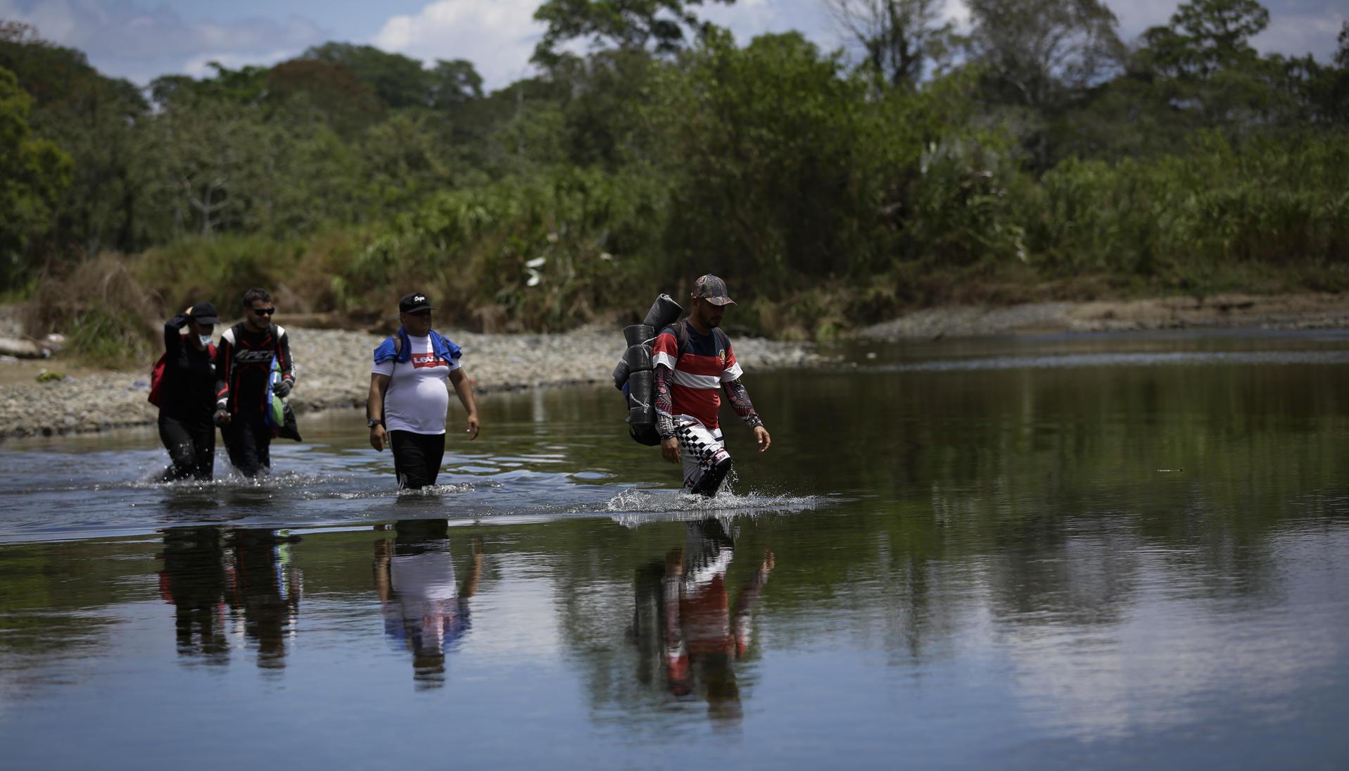 Personas migrantes cruzan el río Tuquesa, en Darién (Panamá), en una fotografía de archivo. 